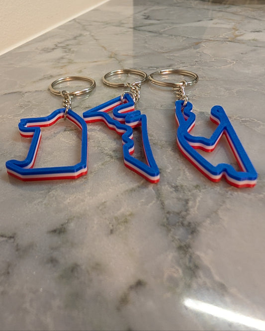 USA F1 circuit key chains in red, white and blue colorway on a quartz countertop.
